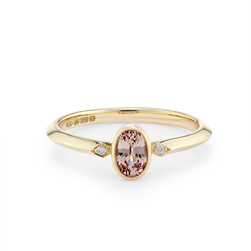 Oval peach coloured sapphire engagement ring with diamonds 
